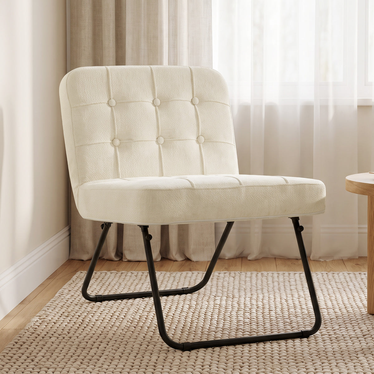 Cream chenille lounge chair with tufted back and padded seat, black folding metal base.
