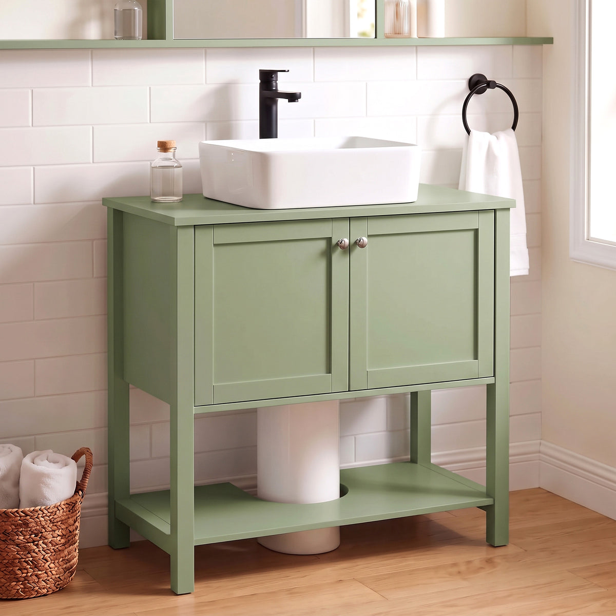 Green under-sink bathroom cabinet with two doors and open shelf beneath.
