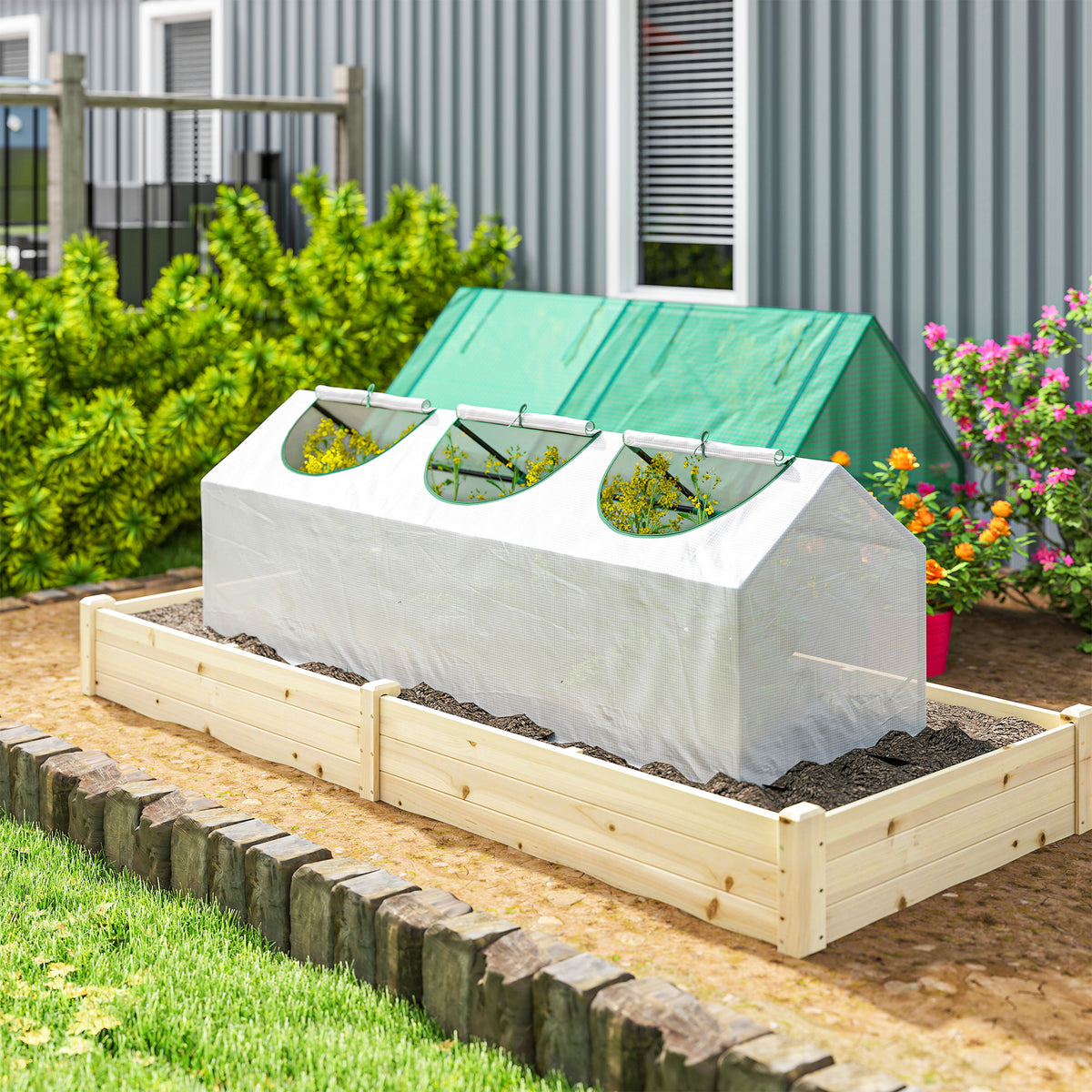 Portable mini greenhouse on wooden raised bed with white cover and green-trim zip windows