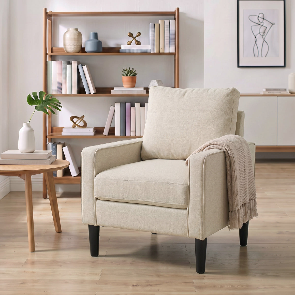 Cream accent chair with removable pillow and draped throw blanket on the arm