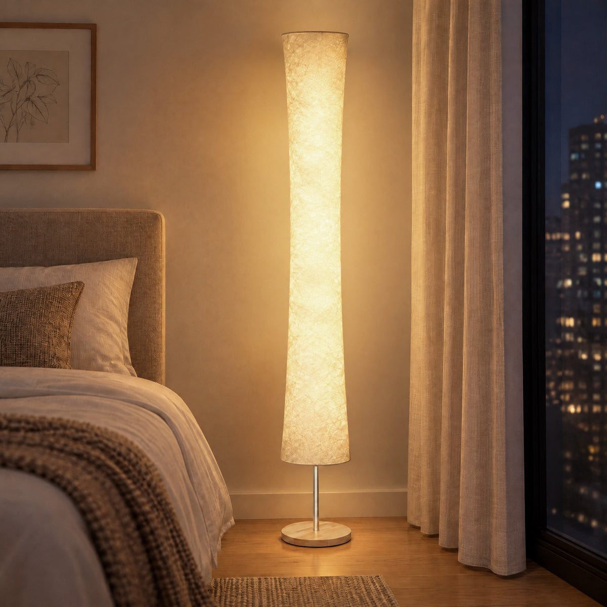 Warm glowing floor lamp with paper shade and pine base beside a bed