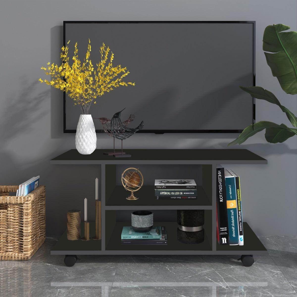 Modern black TV stand with shelves holding books, decorative globe, candles, vase with yellow flowers, and bird sculpture
