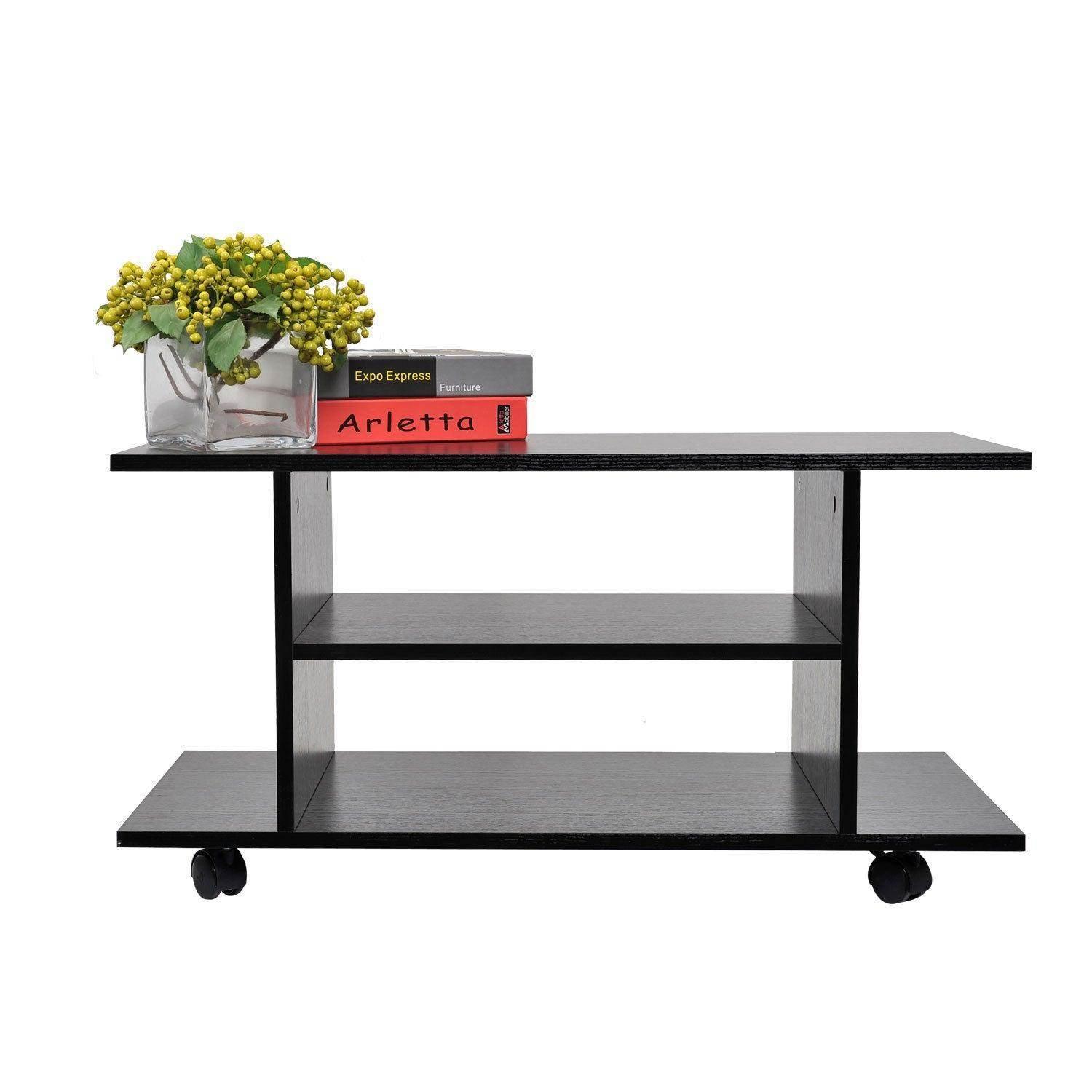 Black TV stand with three shelves on wheels, decorated with a glass vase of yellow berries and two stacked books