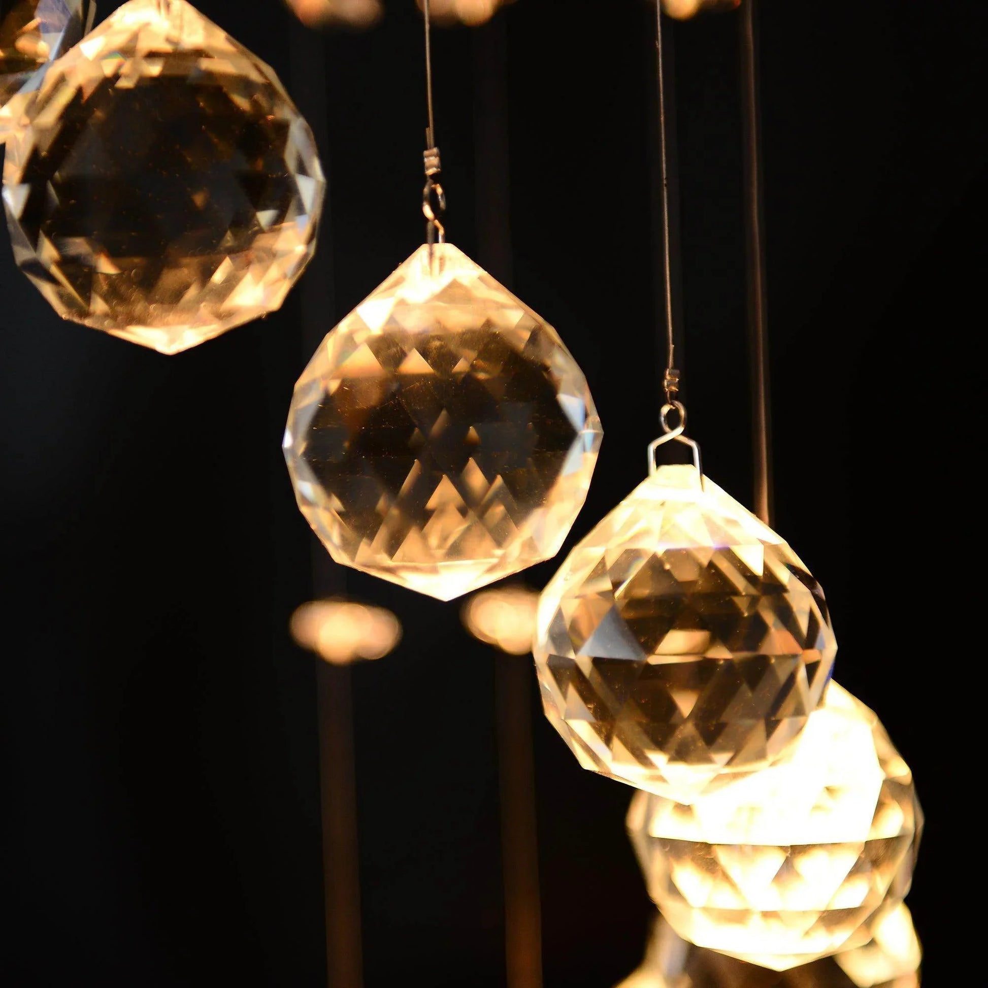 Close-up of faceted crystal octagon pendants from a spiral crystal chandelier glowing warmly on dark background