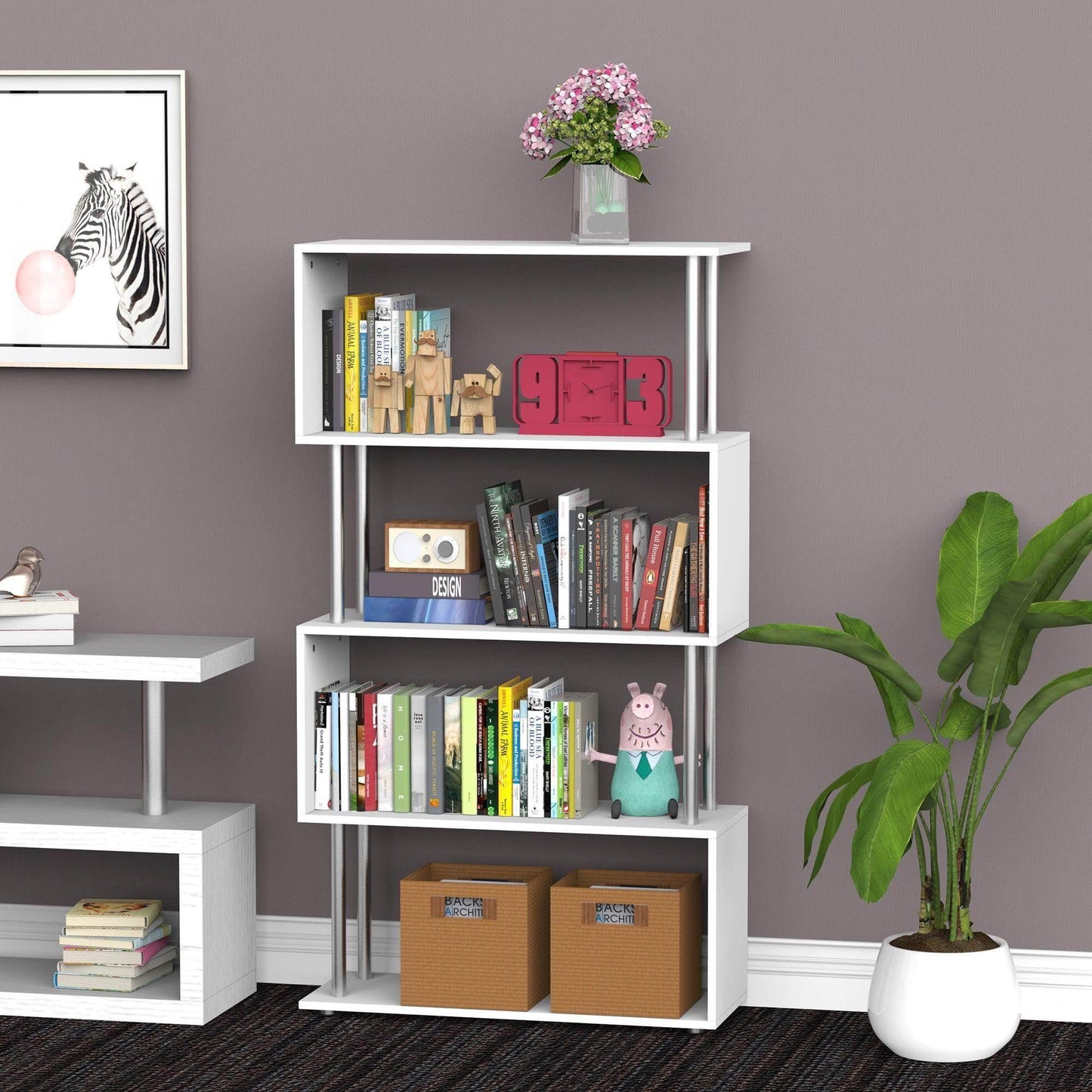 White wooden S-shaped bookcase filled with books, decorative items, and storage boxes by a potted plant