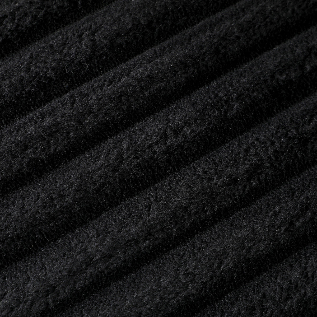 Black corduroy fabric close-up showing dense vertical ribbed texture