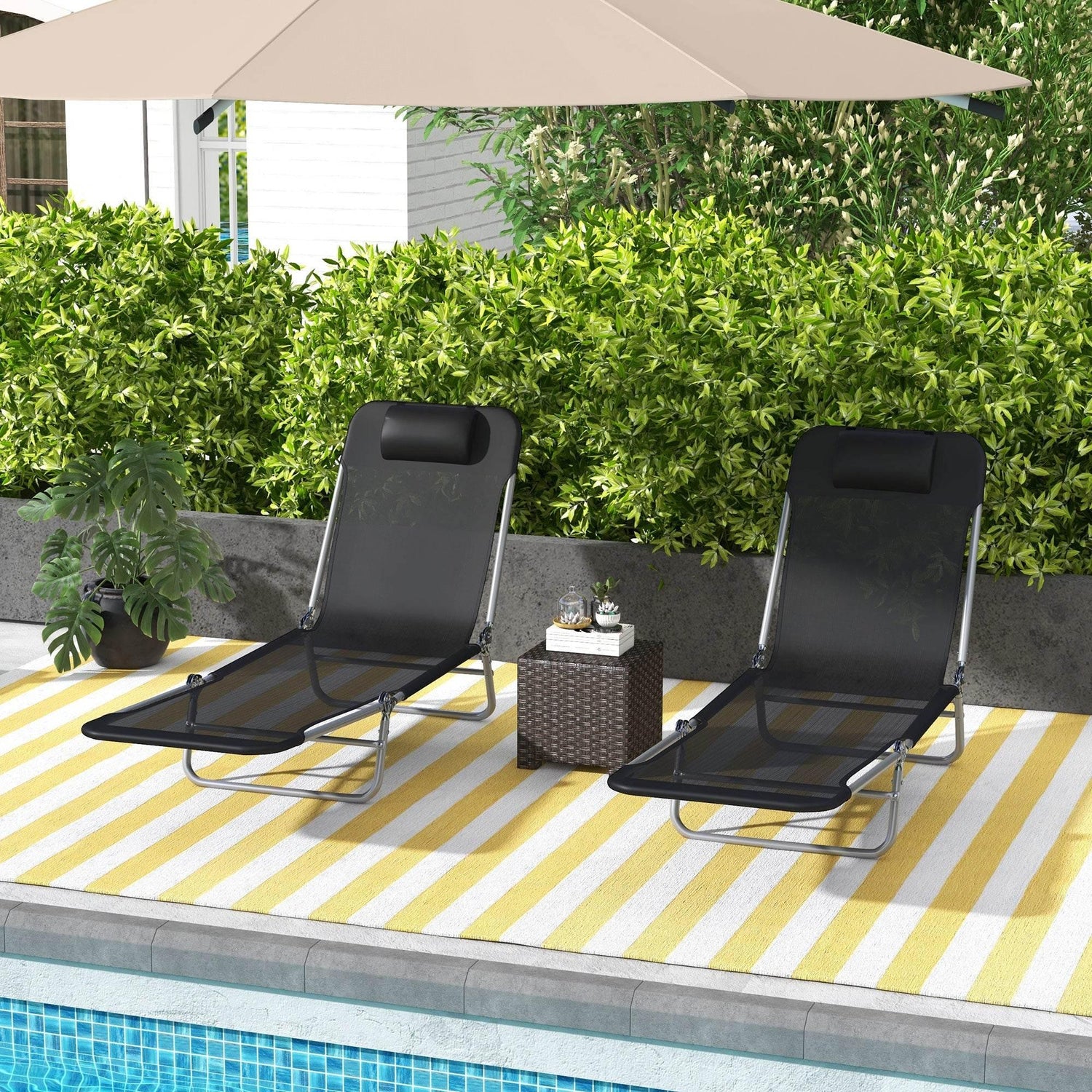 Set of two black adjustable folding sun loungers, padded headrest, steel frame