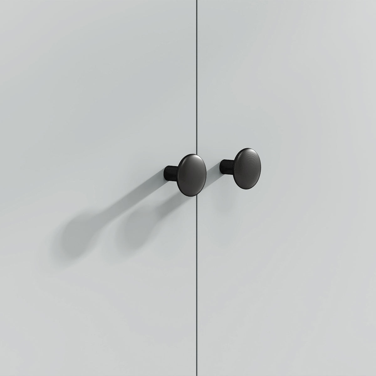 Black round knobs on a light gray rolling kitchen island cabinet door