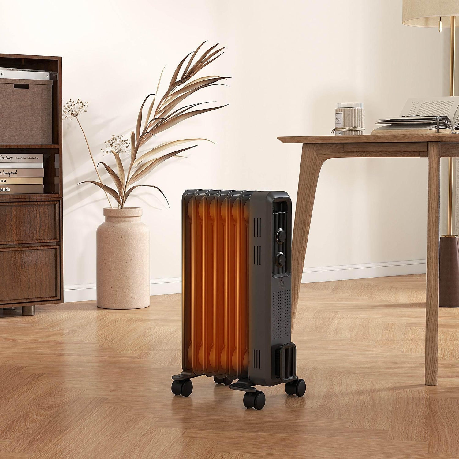 Grey oil-filled portable heater with orange fins, control knobs, and rolling casters