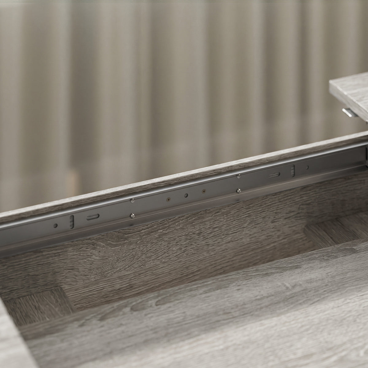 Underside close-up of grey wood-effect extendable oval dining table extension guide rails.