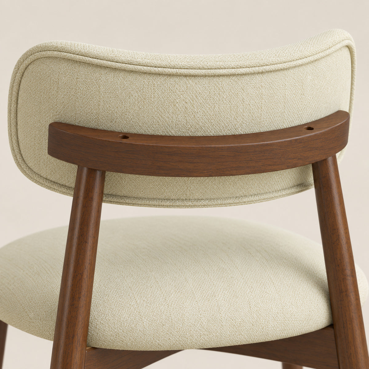 Beige chenille upholstered dining chair close-up with rounded seat and wooden legs