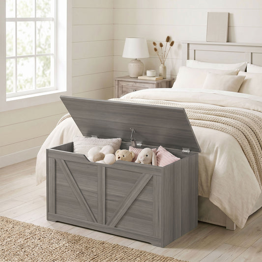 Dark grey wood-effect storage trunk with flat lid open, holding soft toys and pillows