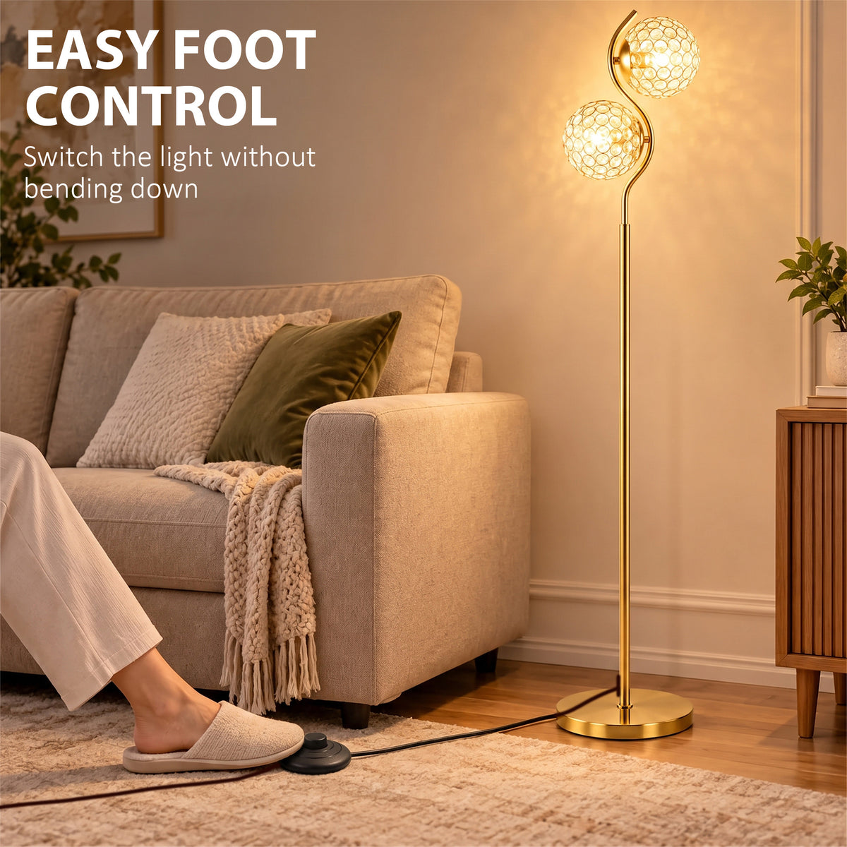 Dual head floor lamp beside sofa with two lit crystal globe shades and gold base