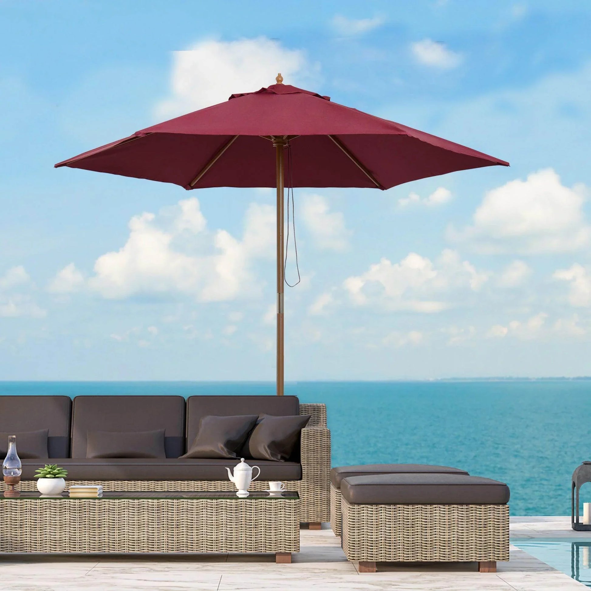 Wooden garden parasol umbrella in red wine with wicker outdoor sofa set by the sea
