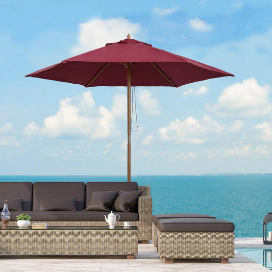 Wooden garden parasol umbrella in red wine with wicker outdoor sofa set by the sea