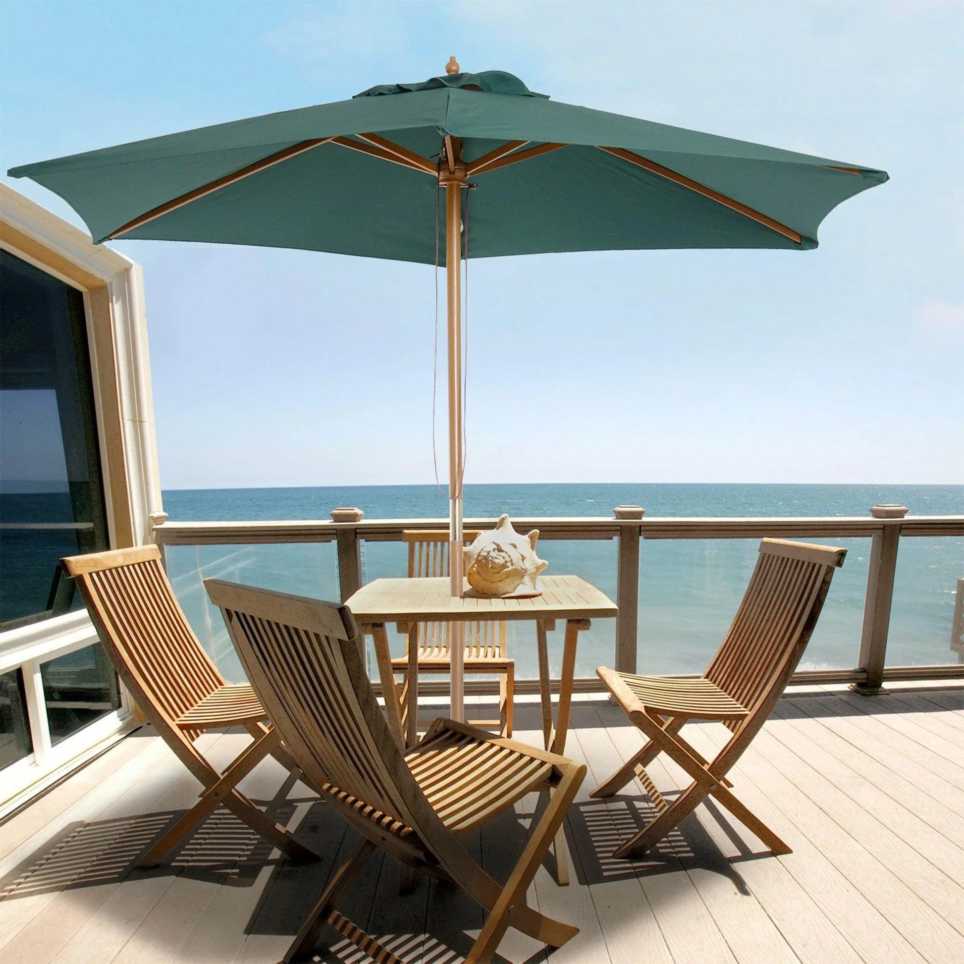 Dark green wooden garden patio parasol over outdoor table and chairs by the sea
