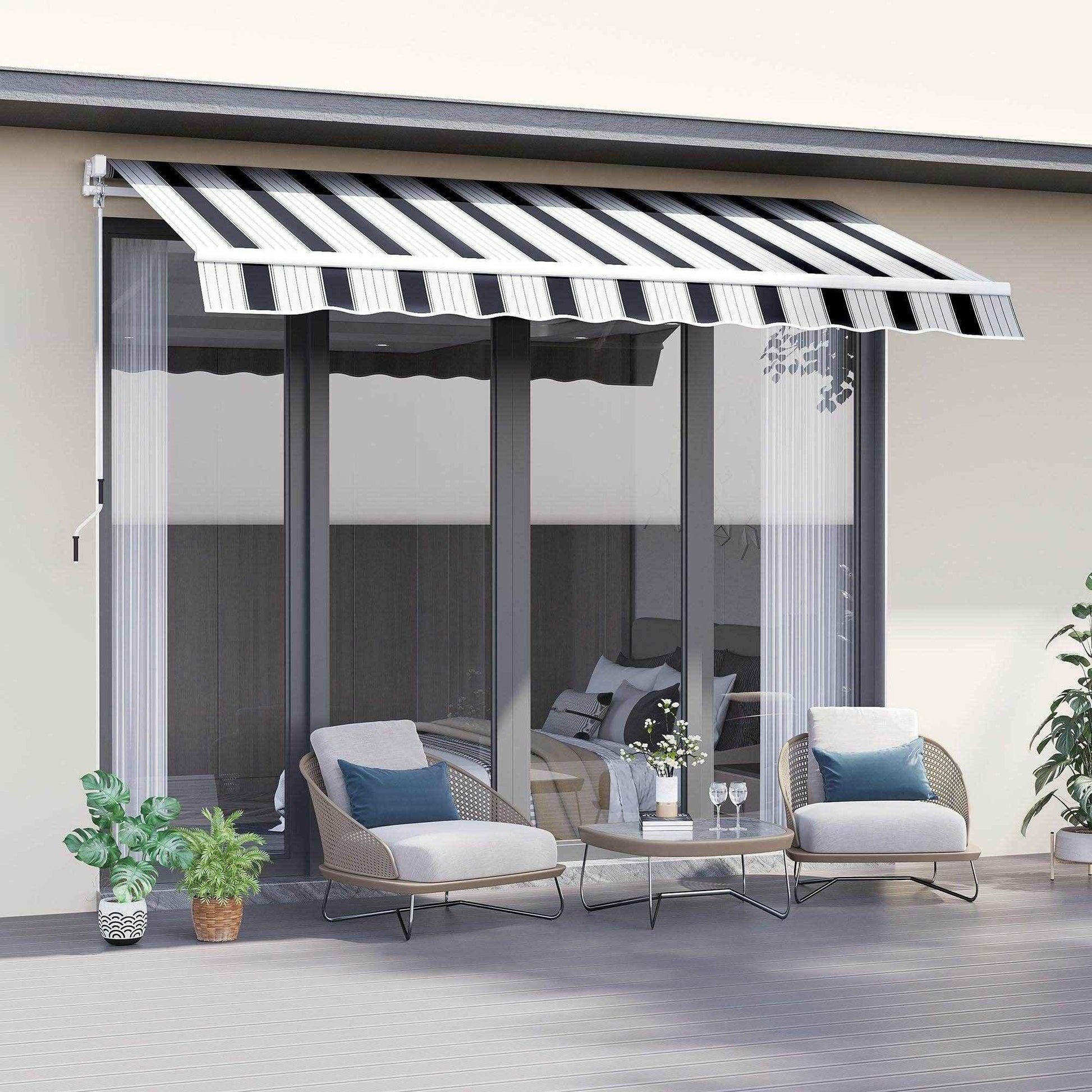Blue and white striped manual awning with winding handle shading modern patio seating area