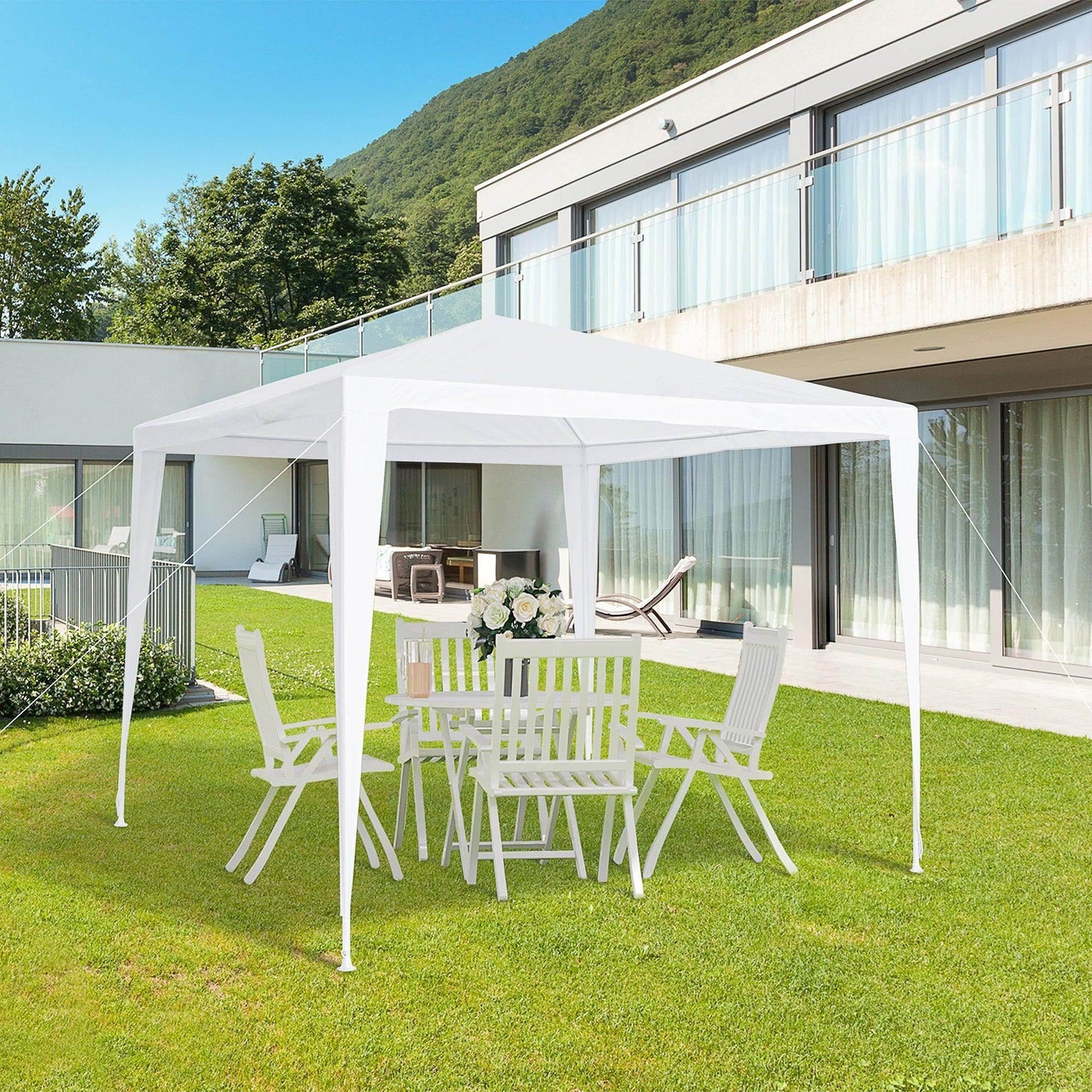 White garden gazebo with outdoor dining set on lawn, modern house and mountain view