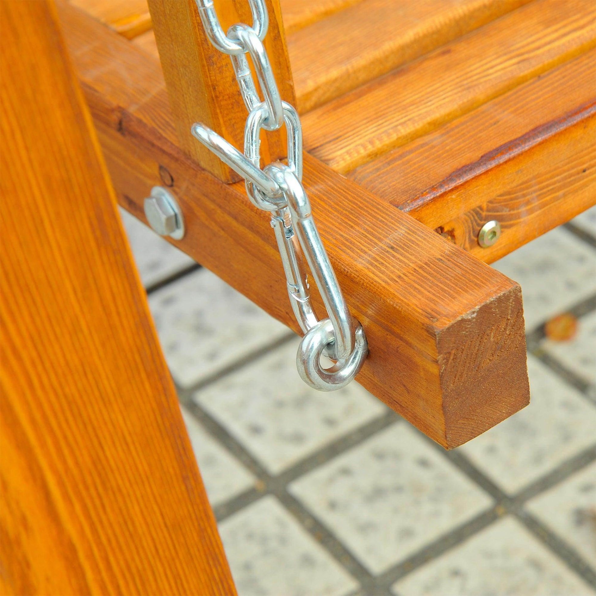 Close-up of wooden garden swing seat with sturdy metal chain attachment, outdoor patio setting