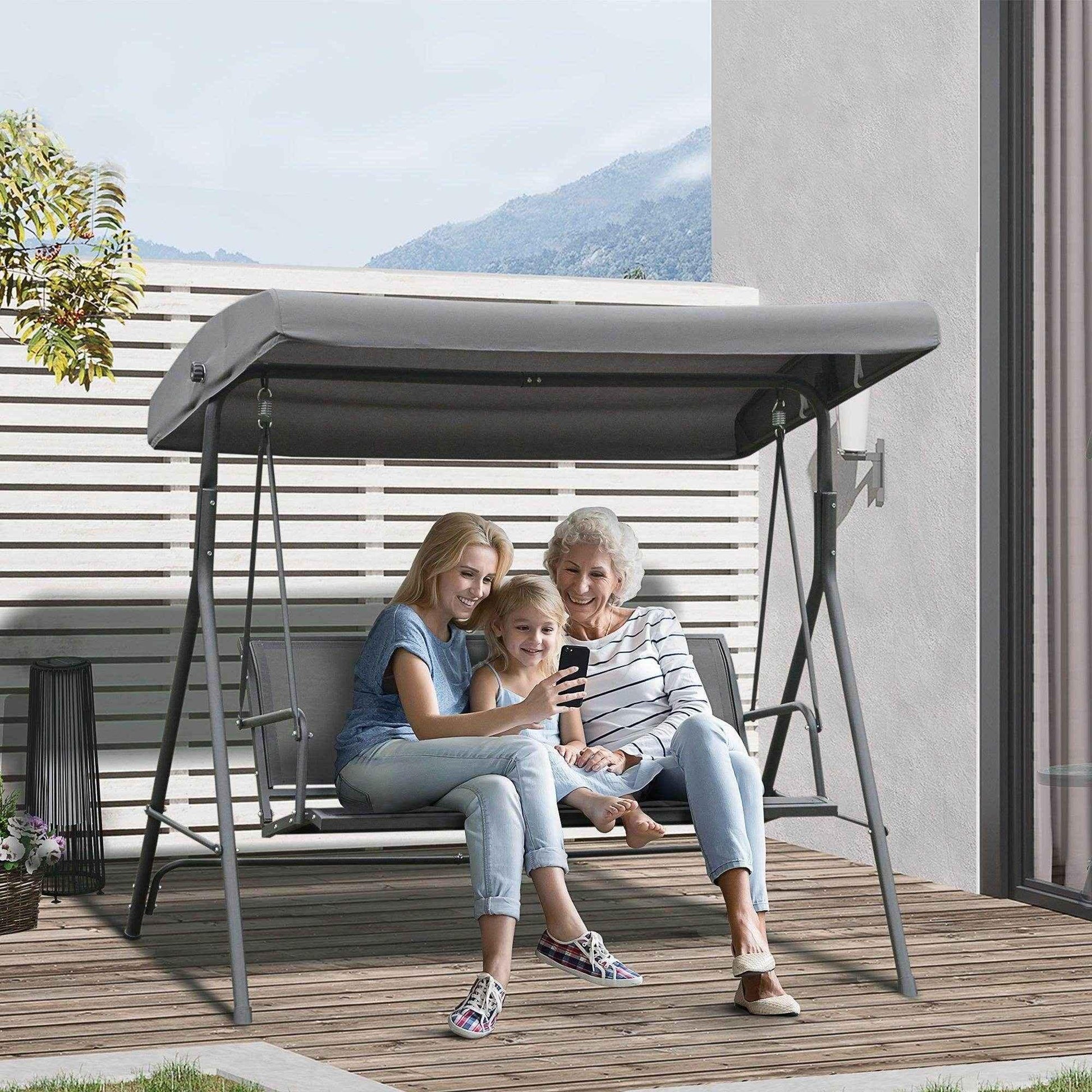 Three-generation family sitting on grey Outsunny 3-seater garden swing chair on wooden deck patio