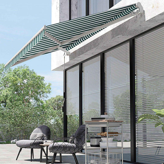 Green and white striped manual awning with winding handle installed above patio seating area with two cushioned chairs