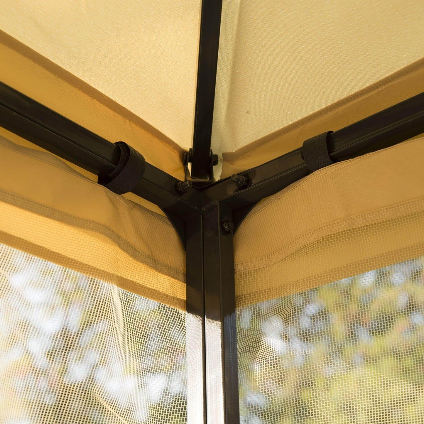 Close-up of beige outdoor gazebo corner with black metal frame and attached mesh side panels