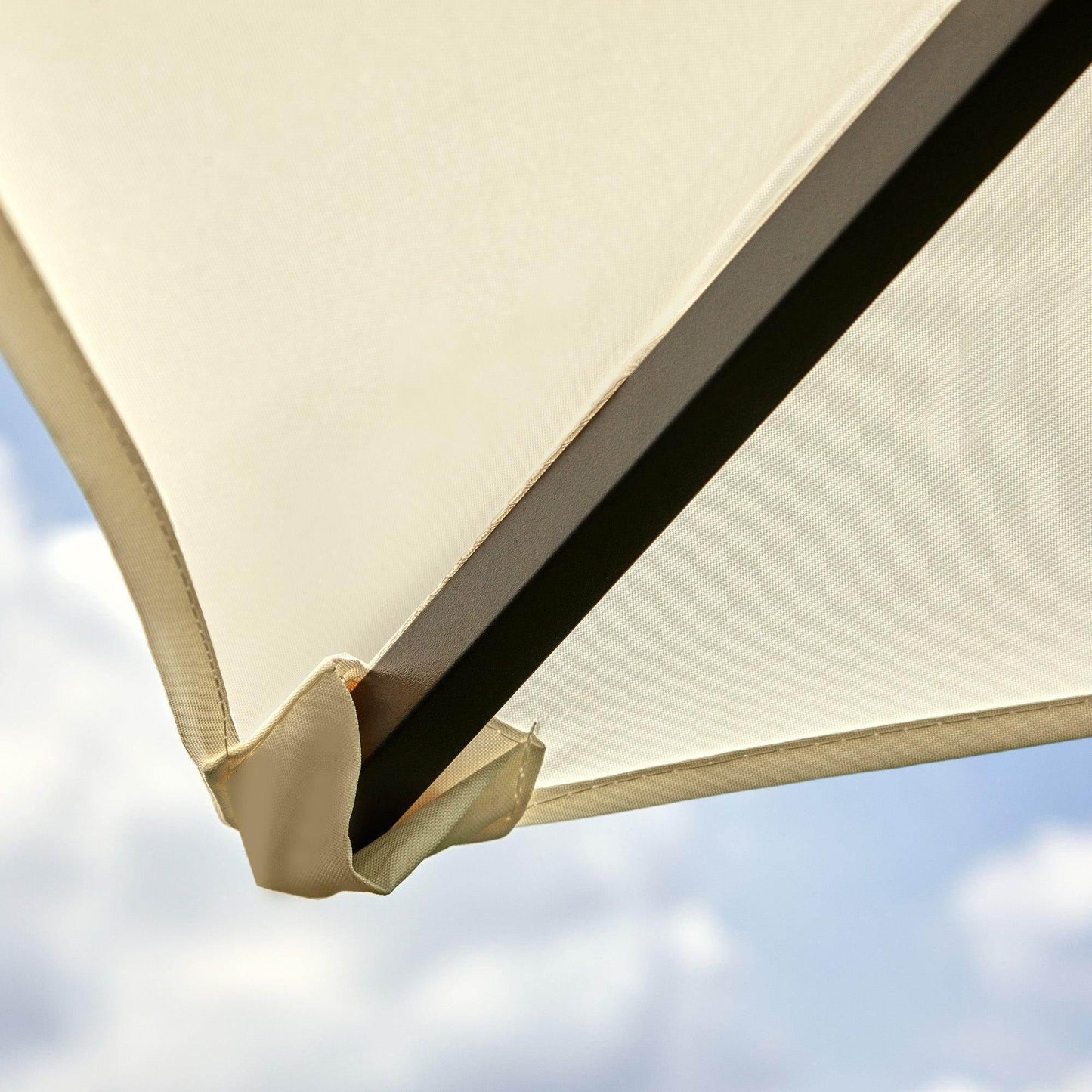 Close-up of cream-colored fabric roof and metal frame of a 3x3m garden gazebo against blue sky