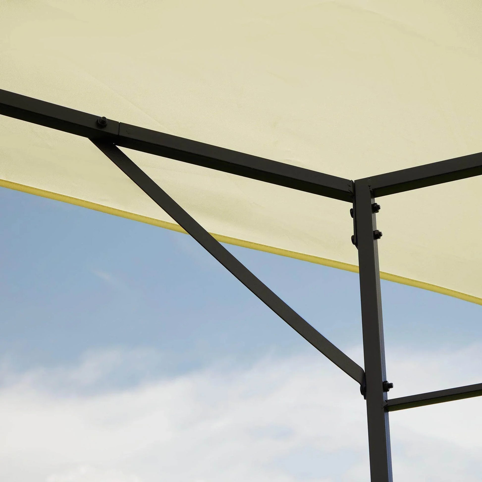 Close-up of black metal frame and cream fabric roof of 3x3m garden gazebo against blue sky