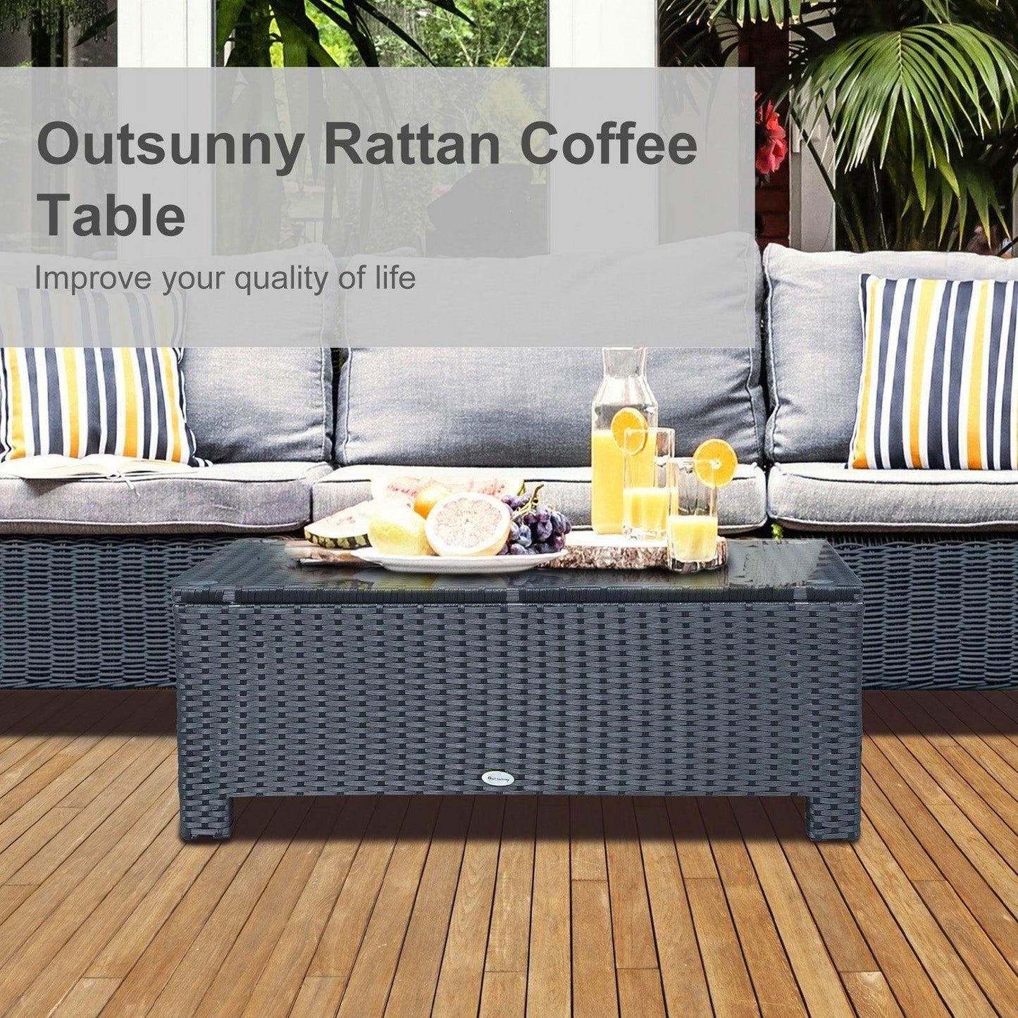 Black rattan coffee table on patio deck with fruit and juice, outdoor sofa in background