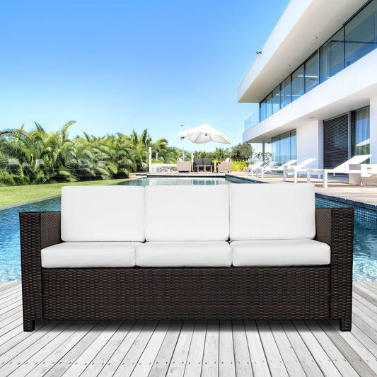 Outdoor dark brown rattan 3-seater sofa with white cushions on poolside deck at modern home