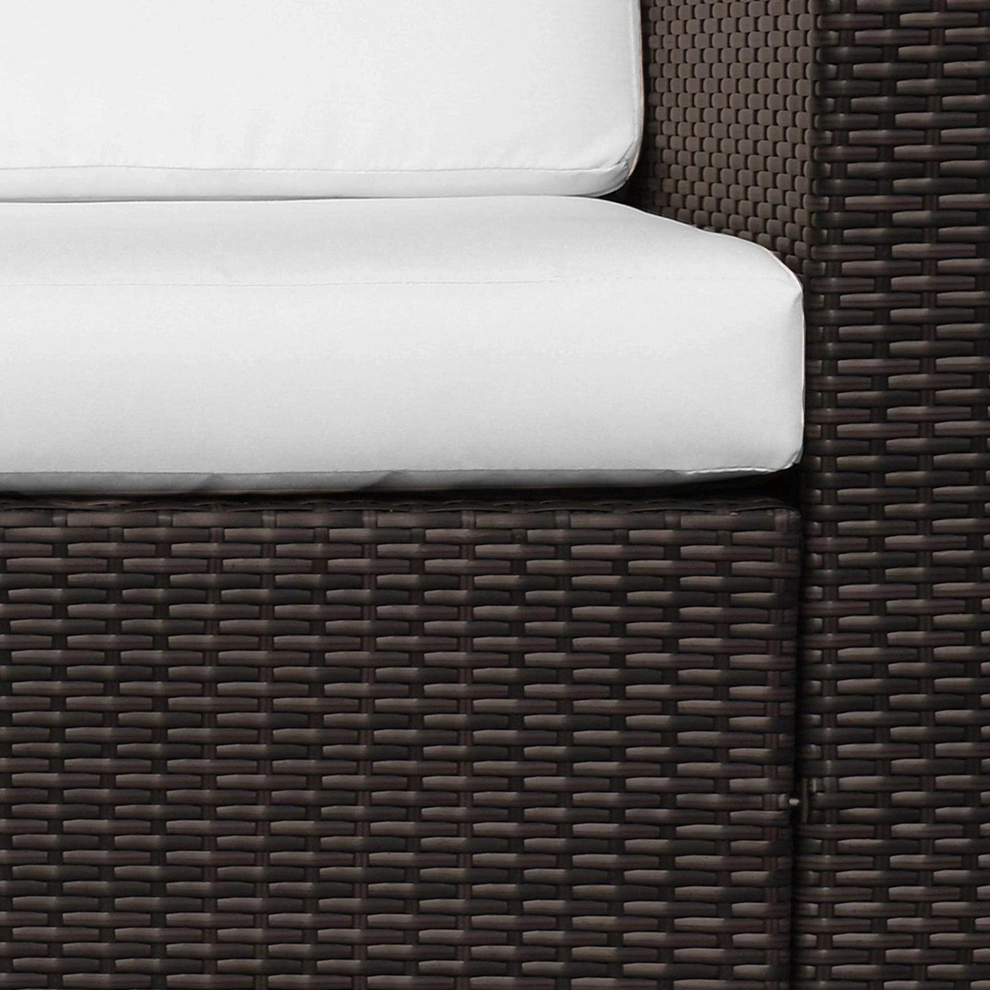 Close-up of brown rattan 3-seater outdoor chair with white cushions and sturdy metal frame