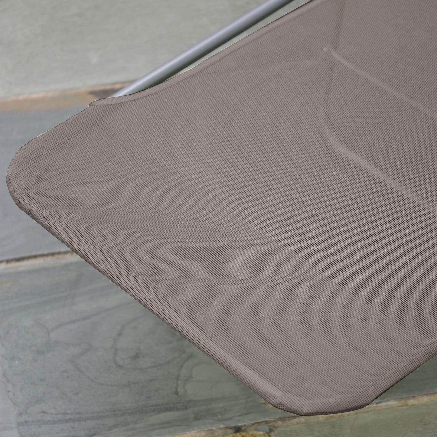 Close-up of a coffee-colored Outsunny garden lounger fabric with metal frame on stone patio