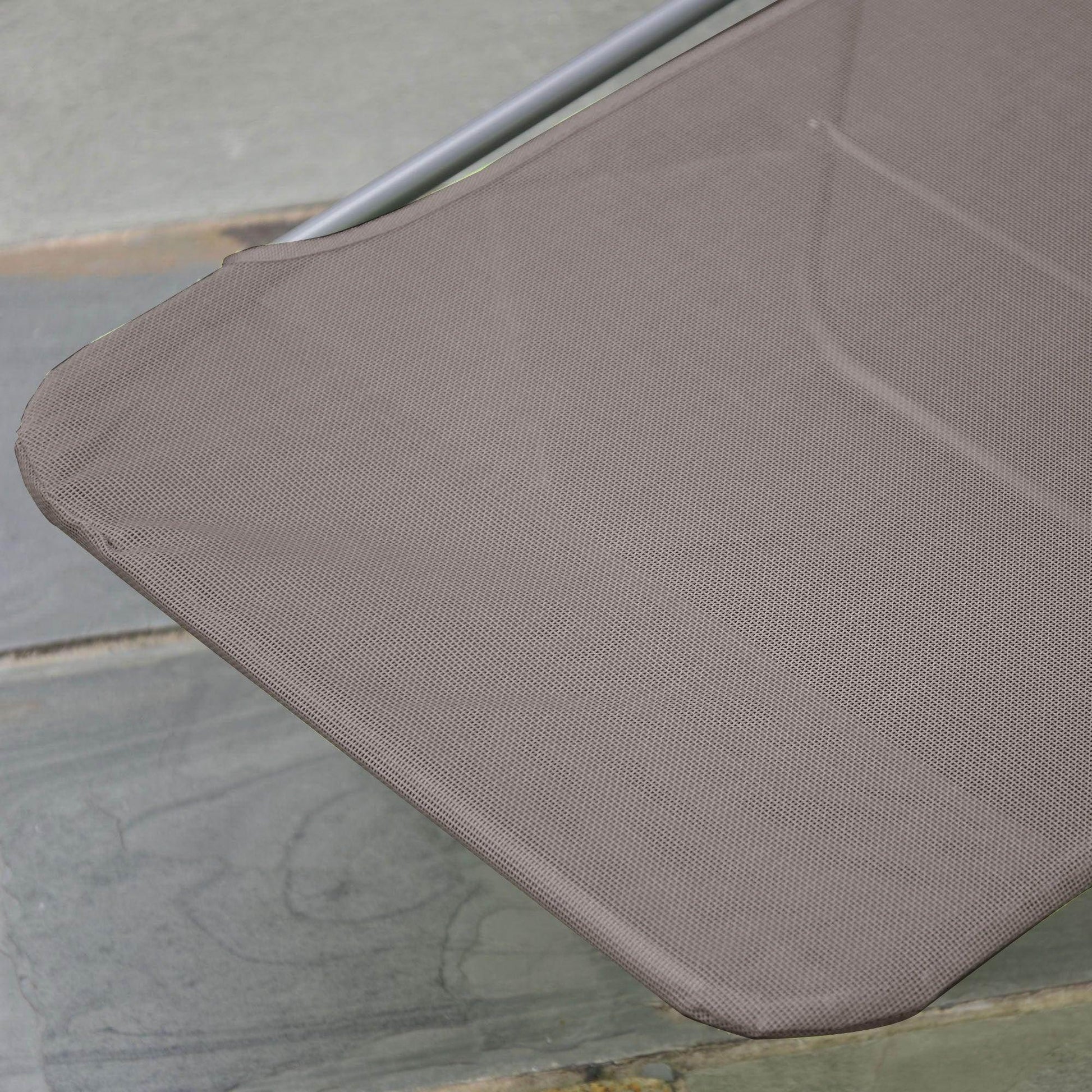 Close-up of a coffee-colored Outsunny garden lounger fabric with metal frame on stone patio