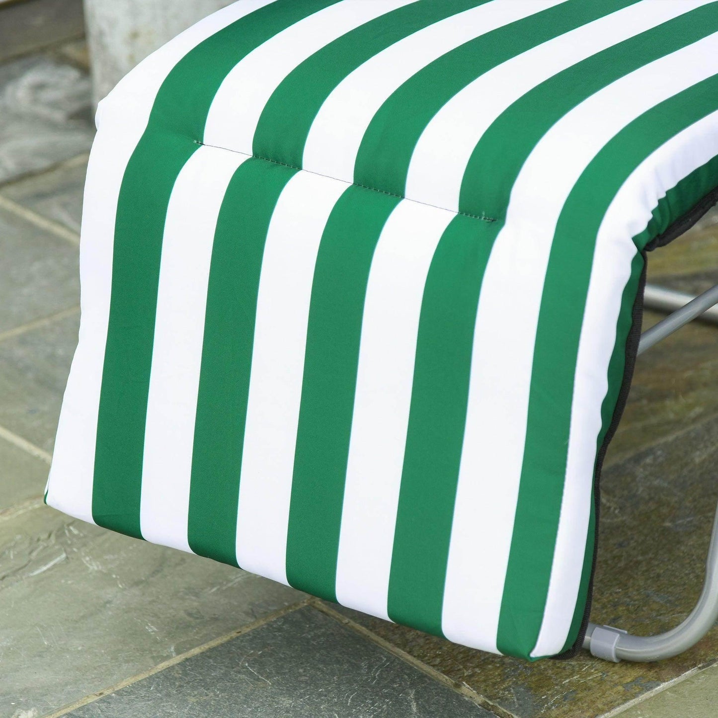 Green and white striped padded footrest of outdoor garden patio sun recliner on tiled surface