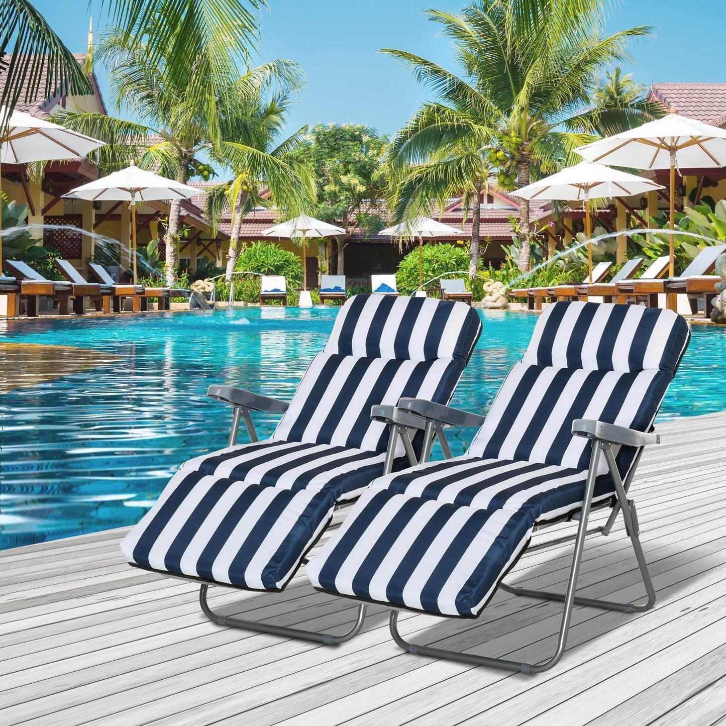 Pair of navy blue and white striped outdoor sun recliners by poolside with palm trees and umbrellas