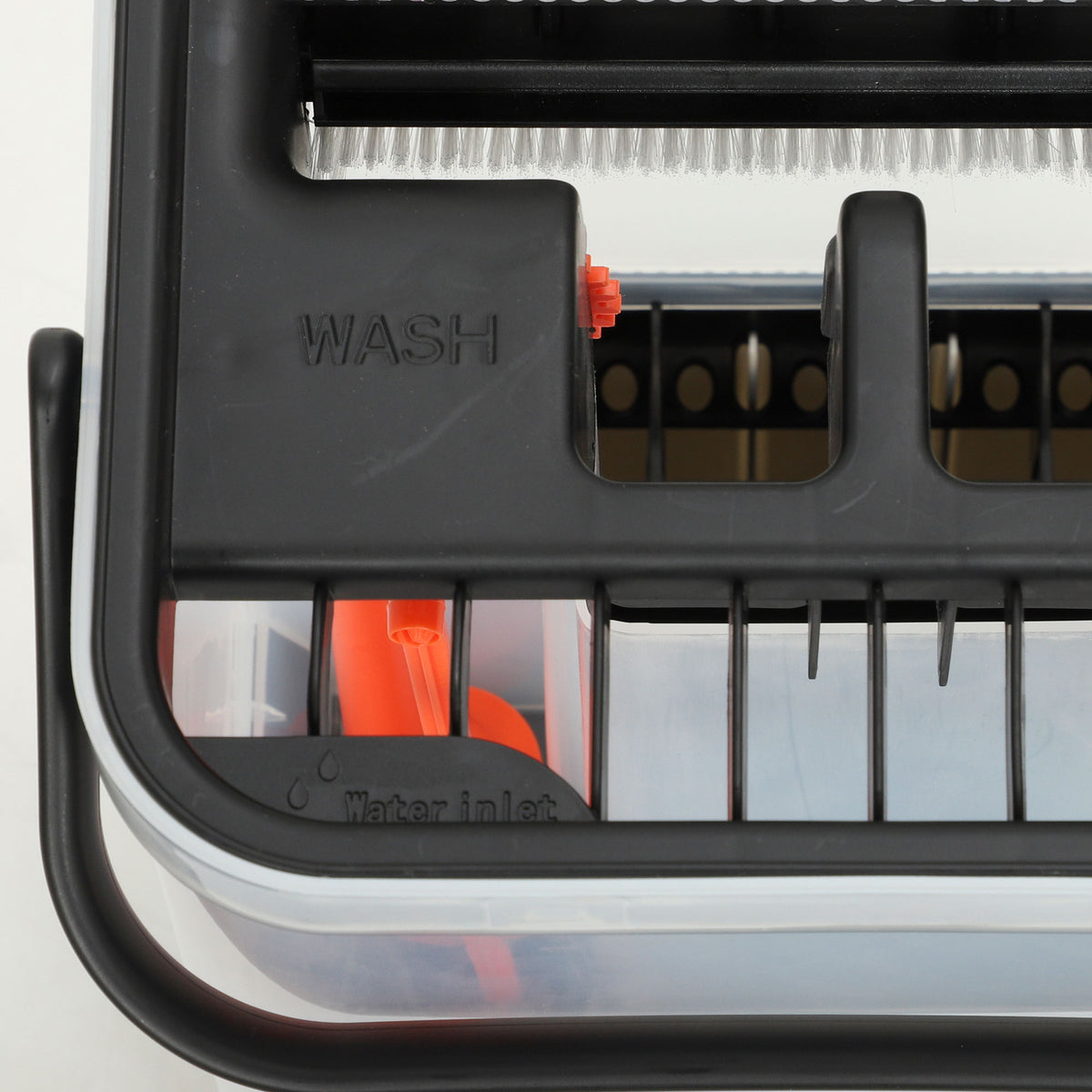 Close-up of dual-chamber wringer with wash compartment and drain grate on cleaning bucket.