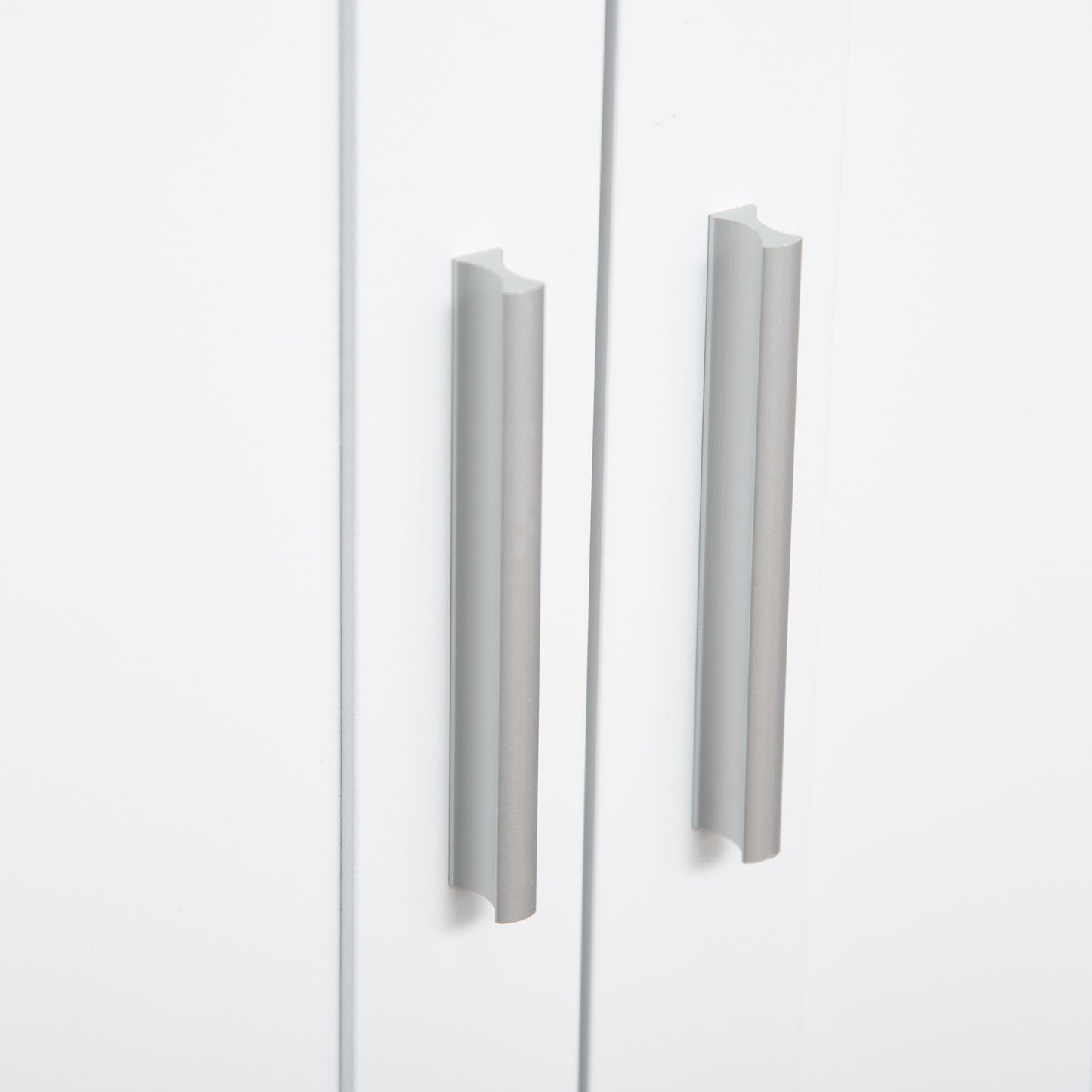 Close-up of silver handles on white cabinet doors, modern home furniture hardware