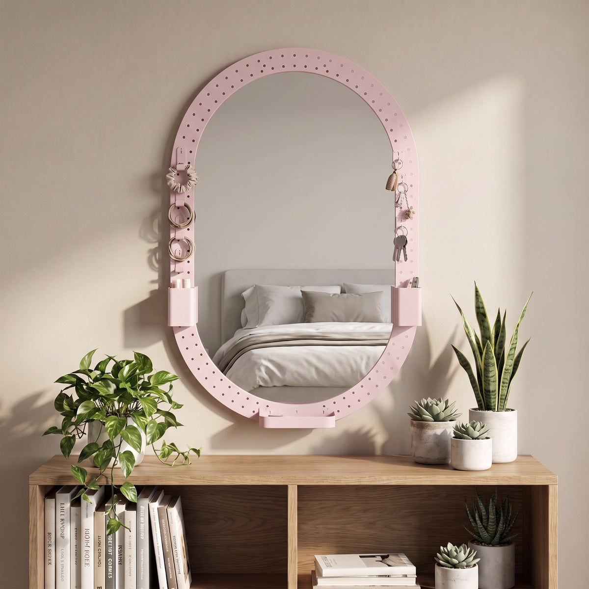 Oval pink pegboard mirror with side hooks and built-in storage holders