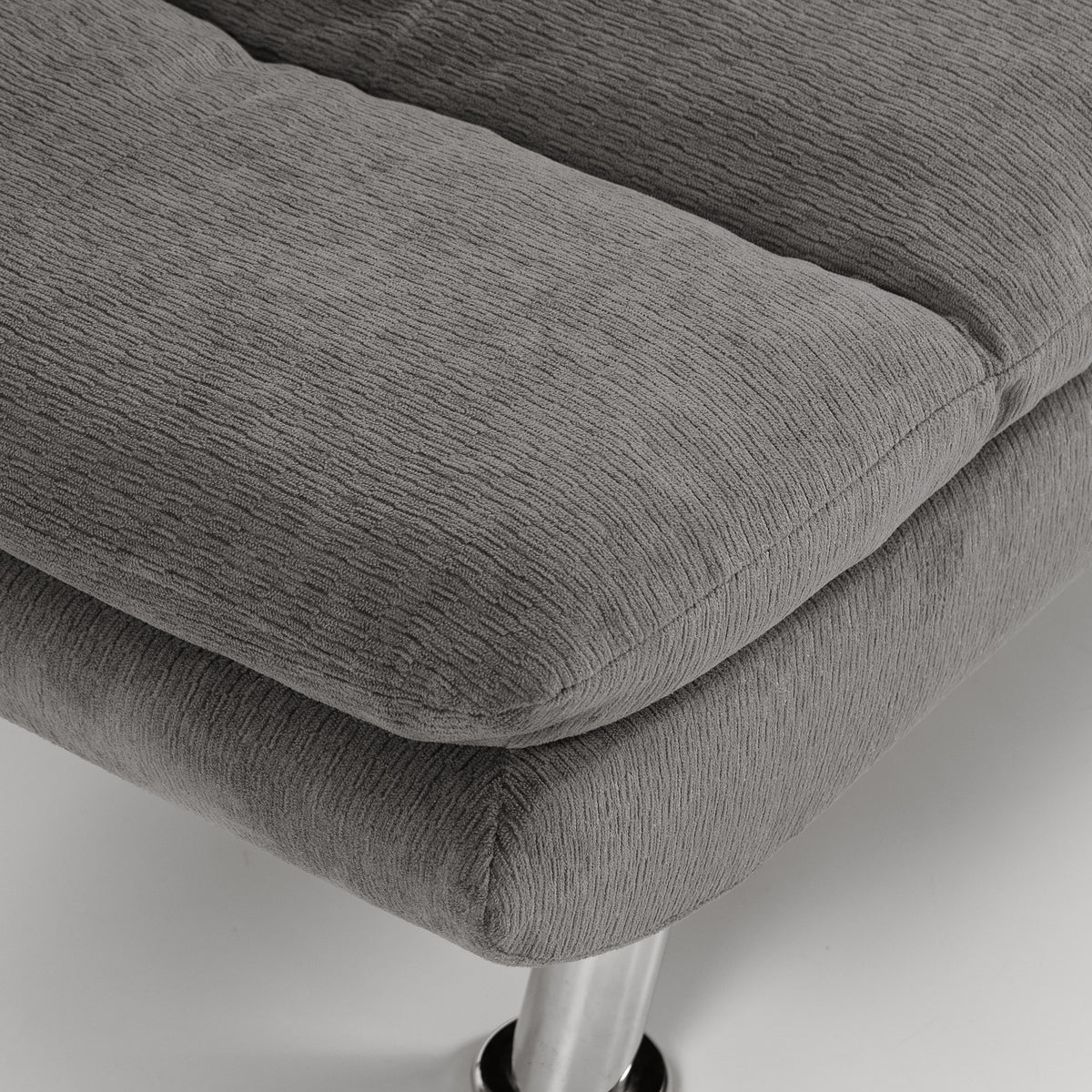 Gray upholstered sofa bed corner with thick cushioned seat and textured fabric