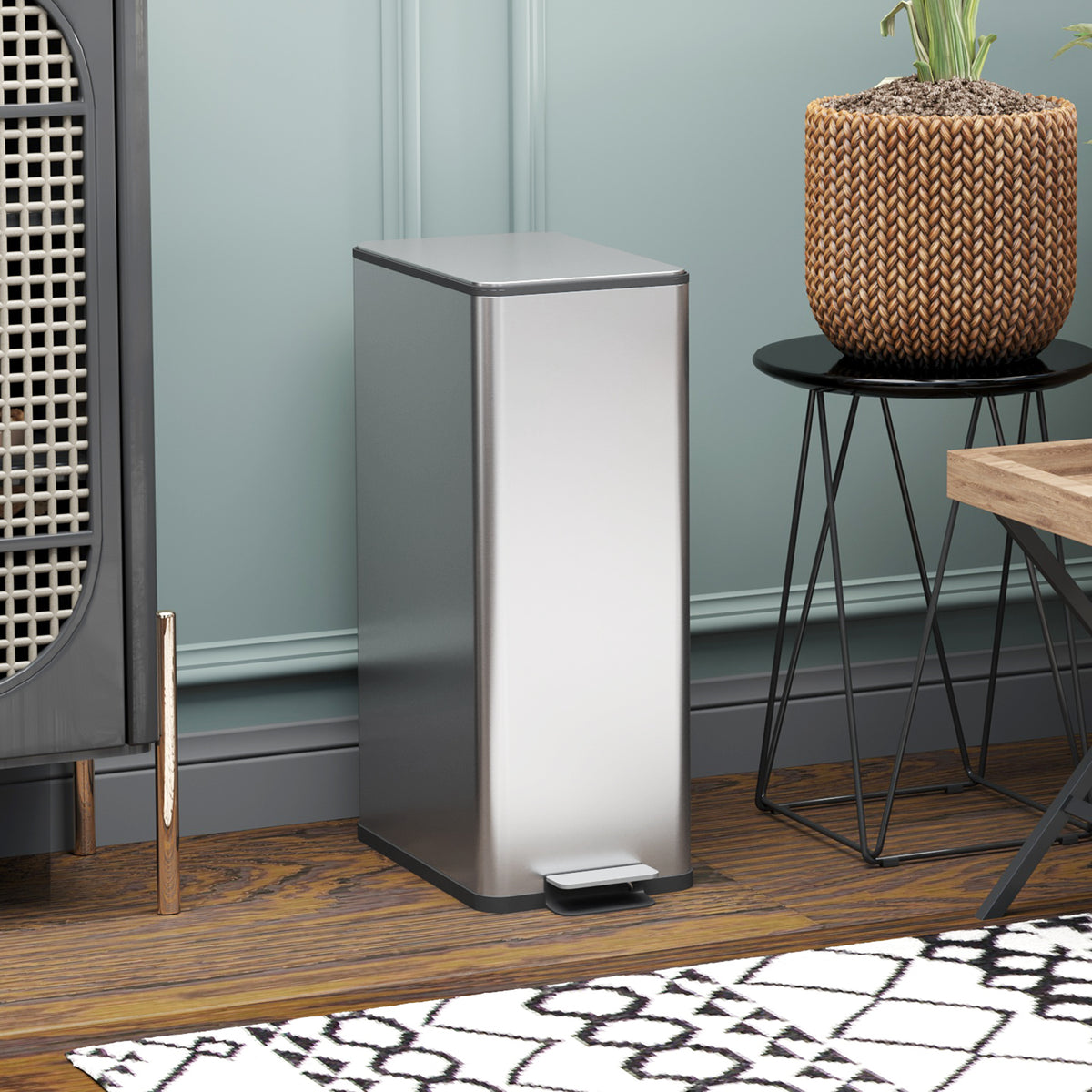 Stainless steel pedal trash can standing upright with black foot pedal base