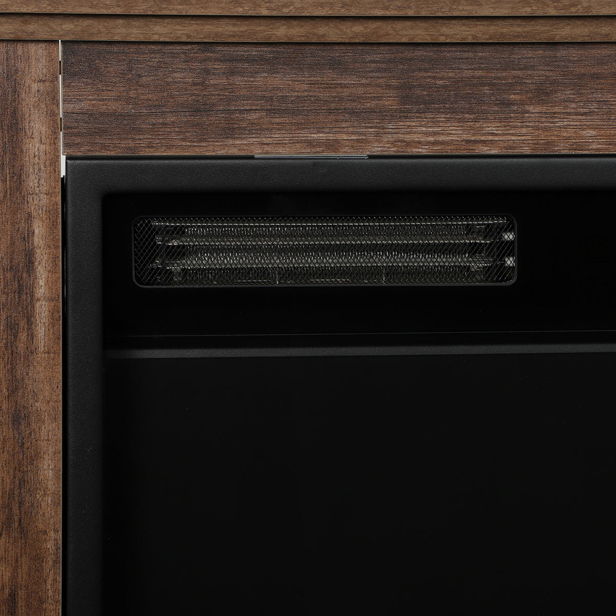 Close-up of vent grille on an electric fireplace insert inside an oak surround