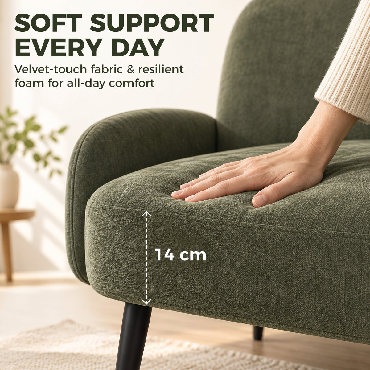 Hand resting on green velvet armrest of sofa, showing comfort padding