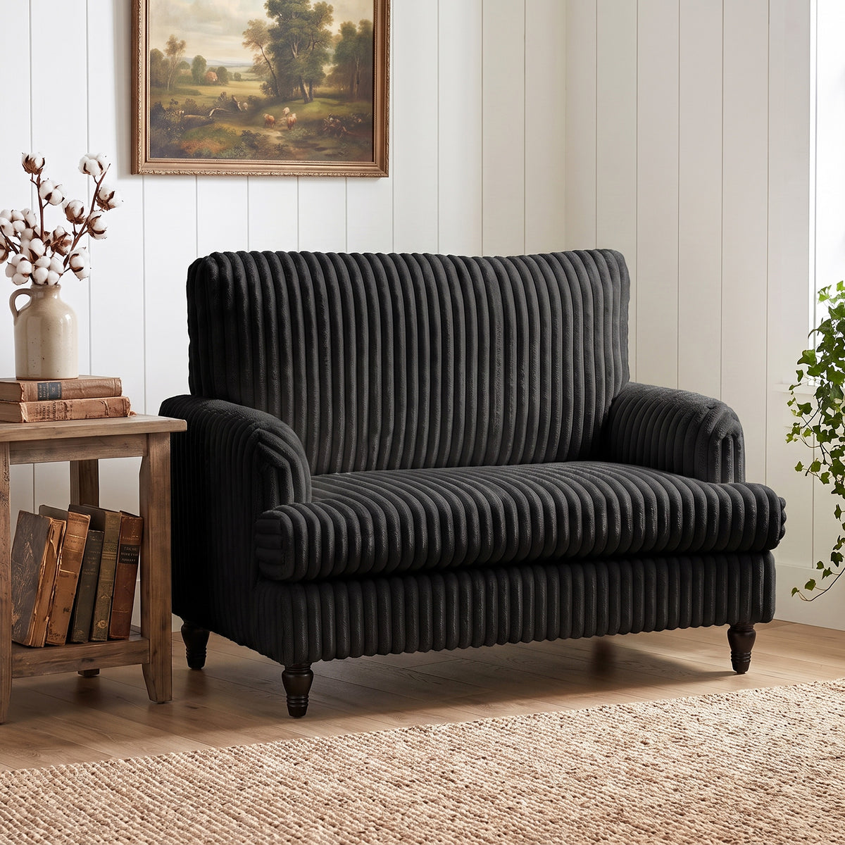 Black corduroy accent armchair with wide seat and tall back, front three-quarter view