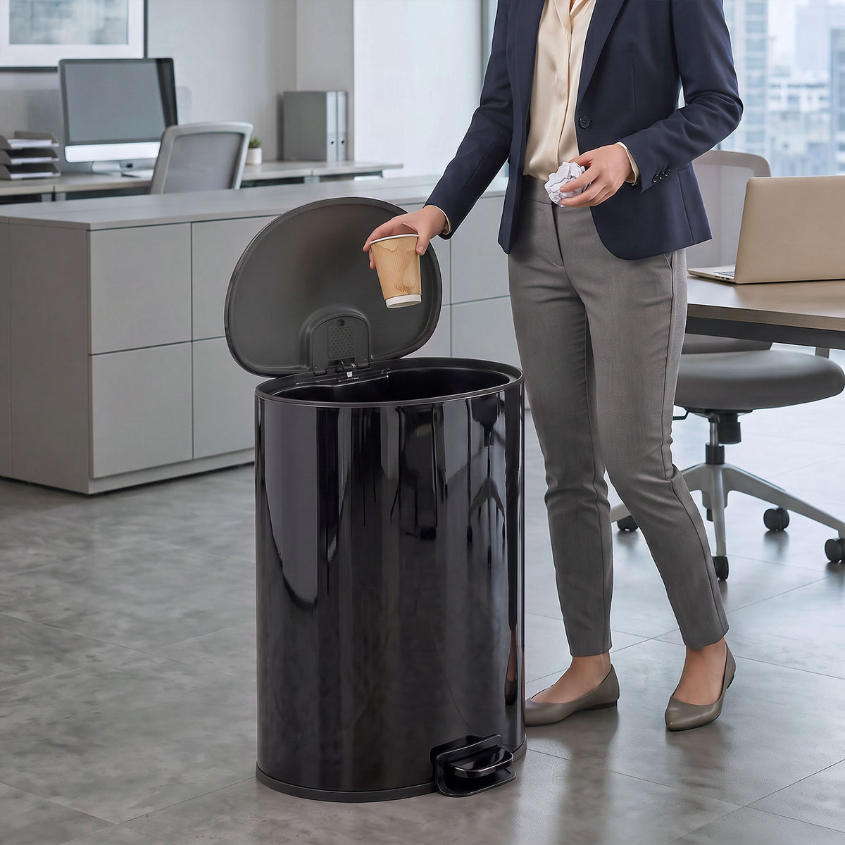 Black stainless-steel kitchen pedal bin with lid open for hands-free disposal