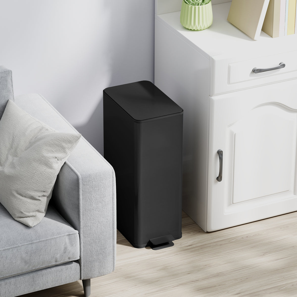 Black kitchen pedal trash can with closed lid and foot pedal at the base.
