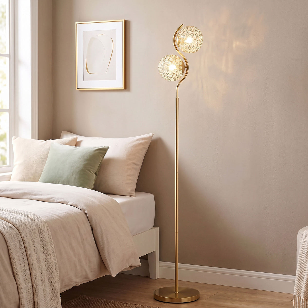 Dual head floor lamp with two crystal globe shades on gold stand near bed