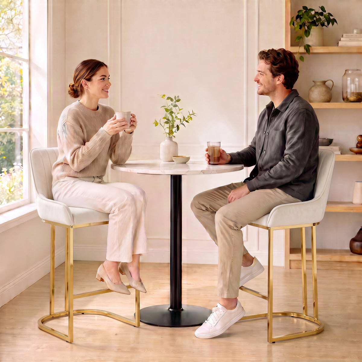 Two cream white velvet bar stools with tall backrest, footrest, and gold cantilever bases