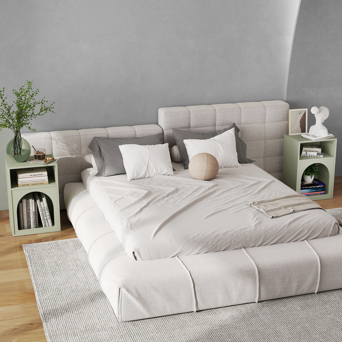Green bedside table set with open compartments and arched front storage next to bedding.
