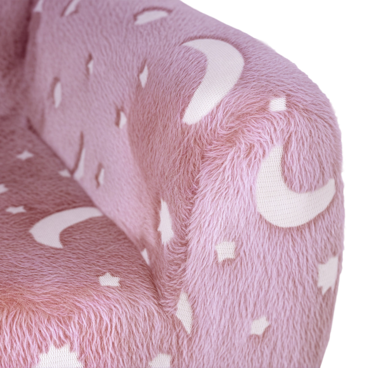 Close-up of pink plush kids armchair fabric with white star, moon, and sparkle patterns