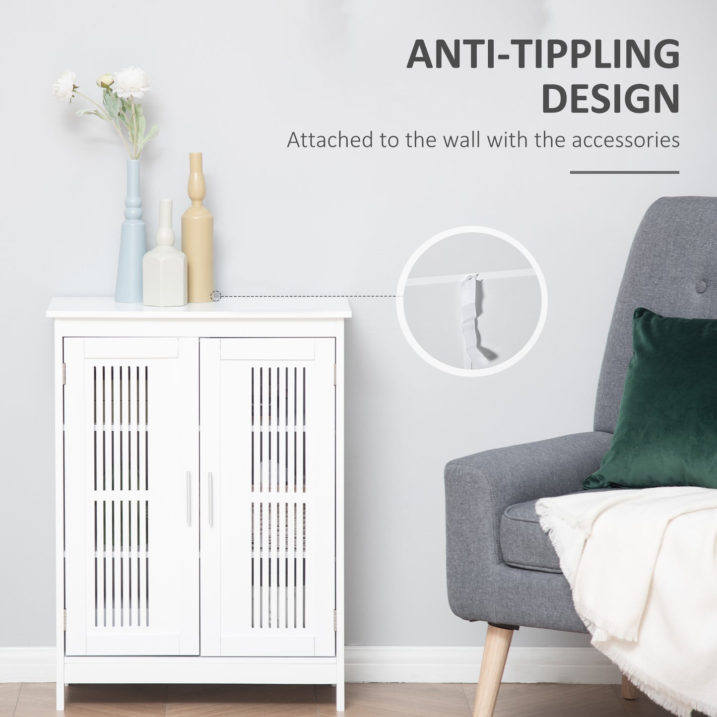 White wooden cabinet with anti-tip wall strap, next to a grey armchair and decorative vases.